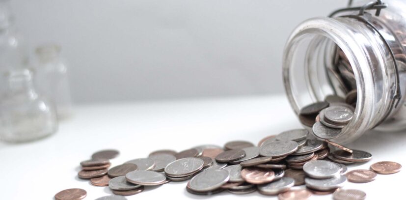 Spilled coins from a glass jar.